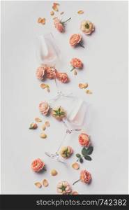 Rose wine and roses on white background, flat lay