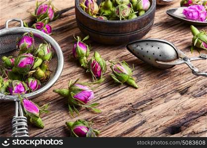 Rosebud.Tea made from tea rose petals. Buds of tea rose for tea on retro wooden background