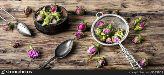 Rosebud.Tea made from tea rose petals. Buds of tea rose for tea on retro wooden background