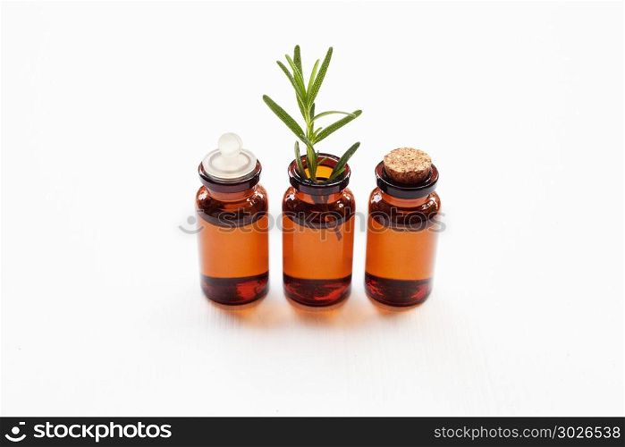 Rosemary essential oil with fresh leaves.. Rosemary essential oil with fresh leaves on white background.