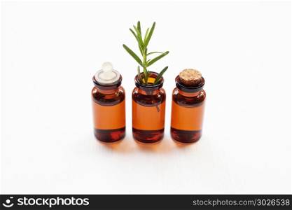 Rosemary essential oil with fresh leaves.. Rosemary essential oil with fresh leaves on white background.