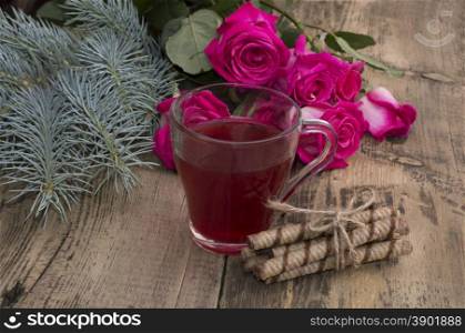 roses, a fir-tree branch and a mug of juice at center