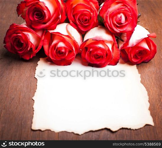 Roses and blank ragged card on the table