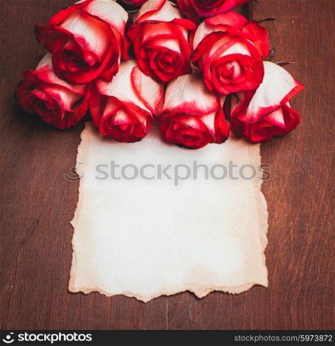 Roses and blank ragged card on the table. Roses and card