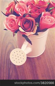 Roses in watering can for decoration with retro filter effect
