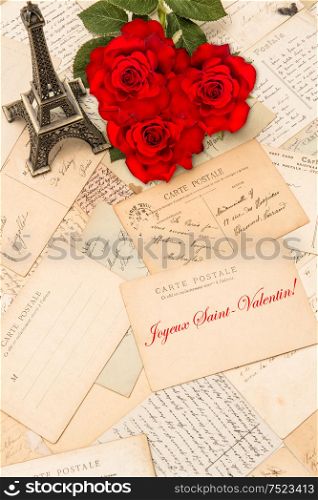 Roses, vintage postcards and souvenir Eiffel Tower from Paris. Sample text Happy St. Valentin in french