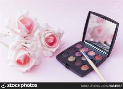 roses with makeup brush eyeshadow palette pink backdrop