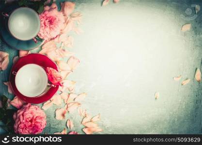 Roses with petals and cups on turquoise background, top view Morning ladies breakfast tea. Teatime