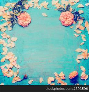 Roses with petals on blue background, top view. Floral frame