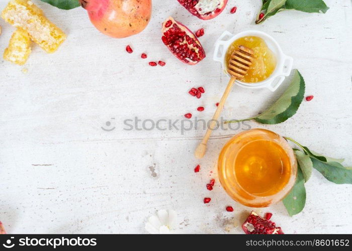 rosh hashana holiday - honey with apple and pomergranate over white desk background with copy space. rosh hashana holiday