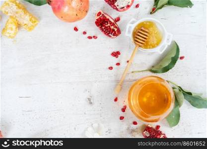 rosh hashana holiday - honey with apple and pomergranate over white desk background with copy space. rosh hashana holiday