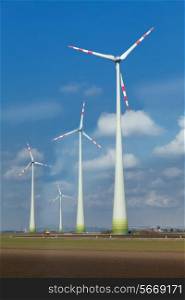 Rotating windmill blades in cloudy blue sky&#xA;