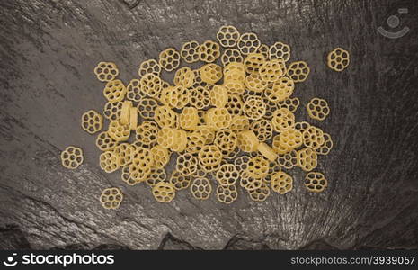 Rotelle Italian pasta from durum wheat on stone background, closeup.