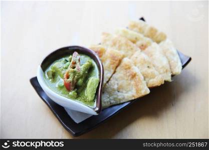 Roti with green curry on wood background