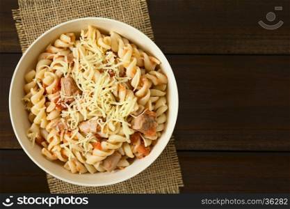 Rotini pasta with tuna and tomato sauce and grated cheese on top, photographed overhead with natural light (Selective Focus, Focus on the top of the dish)