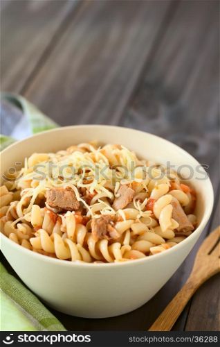 Rotini pasta with tuna and tomato sauce and grated cheese on top, photographed with natural light (Selective Focus, Focus in the middle of the dish)