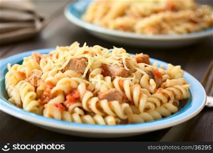 Rotini pasta with tuna and tomato sauce and grated cheese on top, photographed with natural light (Selective Focus, Focus in the middle of the first dish)