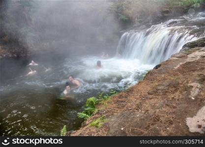 ROTORUA, NEW ZEALAND - SEPTEMBER 1, 2018: People enjoy hot waters of Kerosene Creek Falls. This is a free pool in Rotorua area.