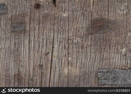 Rotten cracked wood surface with rusty nails and chipped bark. Abstract background with copy space.