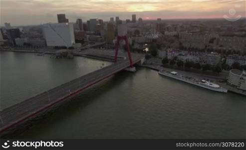 ROTTERDAM, NETHERLANDS - AUGUST 07, 2016: Aerial shot of river and Willem Bridge. Cityscape with White House, Cube House and Markthal at sunset