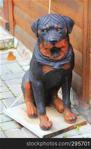 Rottweiler dog statue near house. Service dog sculpture. Beautiful sculpture of black-and-red rottweiler. Statue of domestic animal. Beautiful sculpture of black-and-red rottweiler. Statue of domestic animal