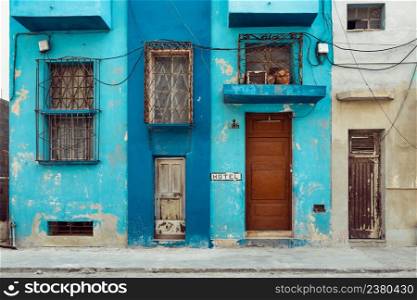 Rough painted facades of buildings with bars on the windows, Havana, Cuba
