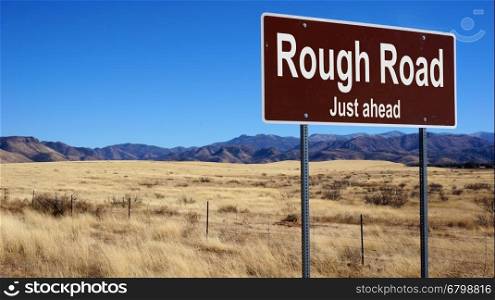 Rough Road road sign with blue sky and wilderness