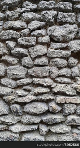 Rough wall lined with large cobblestones, close-up texture