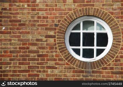 round and vintage wooden window on a brick wall building