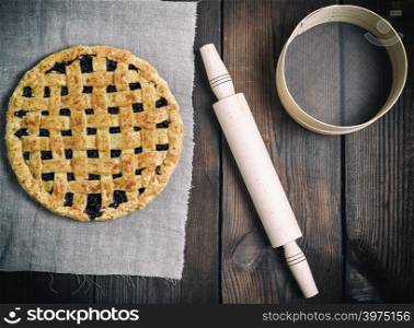 round baked fruit cake on a gray napkin, next to a sieve and wooden rolling pin