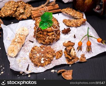round biscuits made from oatmeal and bananas, next to a banana sliced and walnuts on a white paper