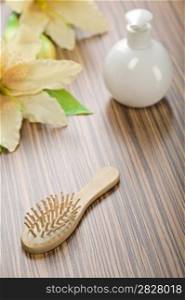 round bottle and hairbrush with flower