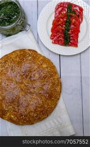 Round bread with sesame, pesto, tomatoes and salt with spices