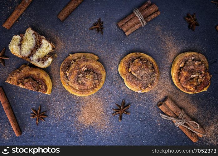 round buns with cinnamon on a black background, top view