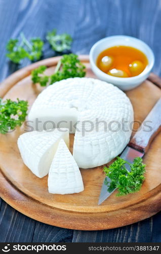 round cheese and aroma spice on wooden board