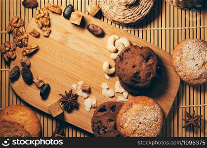 Round crunchy cookies with nuts, cocoa chips and spices on cutting board. Top view with copy space