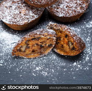 round cupcakes with a pumpkin on a black table, close up