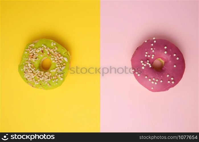 round different donuts with sprinkles on a bright multi-colored background, top view