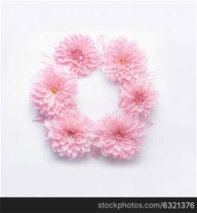 Round frame of pastel pink flowers on white desk background. Floral wreath. Layout for holidays greeting of Mothers day, birthday, wedding or happy event