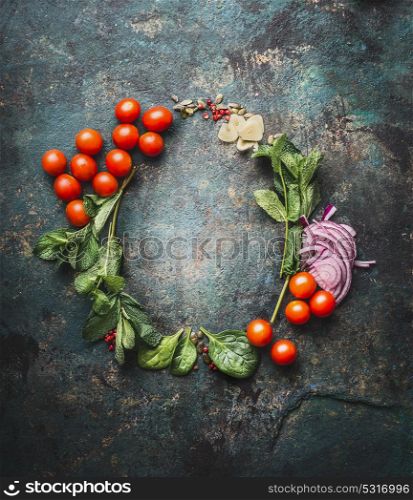 Round frame with vegetarian cooking ingredients on dark rustic background, place for text, frame. Healthy eating and cooking, clean or diet food concept