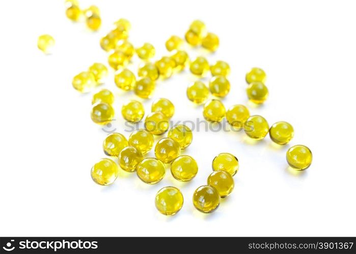 Round golden fish oil capsules on a white background