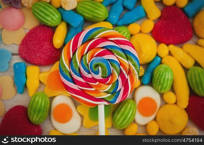 Round lollipop and many candies with different shapes and colors