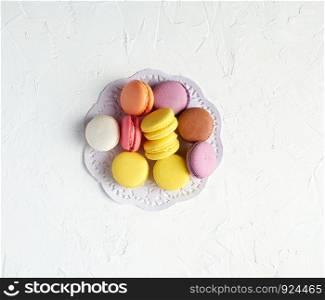 round multi-colored baked macarons with cream, white background, top view