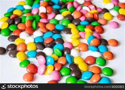 Round, multi-colored candies. Candy closeup on a white background. A pile of multicolored candies. Round, multi-colored candies. Candy closeup on a white background.