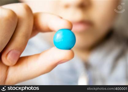 Round, multi-colored, chocolates. Close-up. A child holds a candy. Round, multi-colored, chocolates. A child holds a candy.