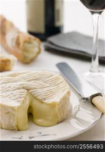 Round of camembert cheese with French stick and Red Wine