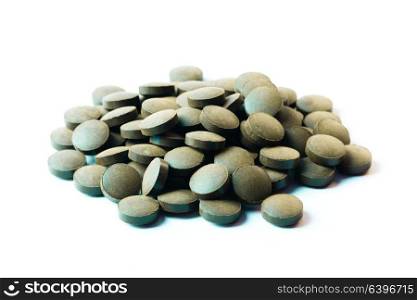 Round pills of Spirulina isolated on white background. Spirulina pills isolated