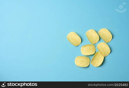 round potato chips on a blue background, top view