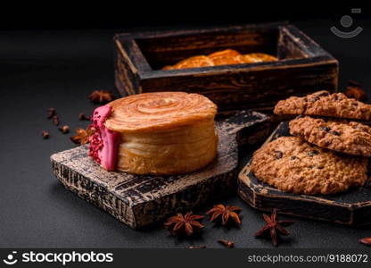 Round puff pastry croissant with raspberry filling or new york roll on dark concrete background