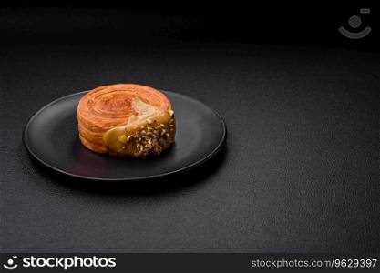 Round puff pastry croissant with raspberry filling or new york roll on dark concrete background